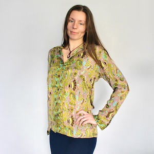 Op de afbeelding: Een lang mouw, groen en bruin paisley-gepatroneerd blouse met een knoopsluiting aan de voorkant en een kraag. De blouse heeft een losse pasvorm en is gemaakt van een zachte, vloeiende stof.