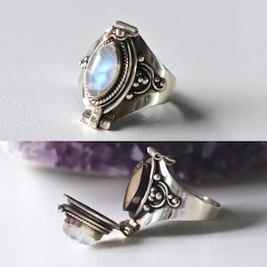 May include: A silver ring with a moonstone set in a hinged oval locket. The locket opens to reveal a small compartment inside.