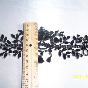May include: Black rhinestone trim with leaf and teardrop designs. The trim is approximately 2 inches wide and is measured with a ruler. The trim is on a white background. The date 01/01/2008 is in the bottom right corner.