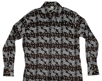 Pode incluir: Uma camisa marrom de manga comprida com botões e estampa de zebra branca.