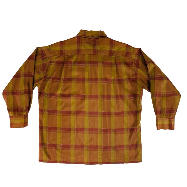 Op de afbeelding: Een lang mouw overhemd met knopen en een geruit patroon in tinten bruin, oranje en rood.