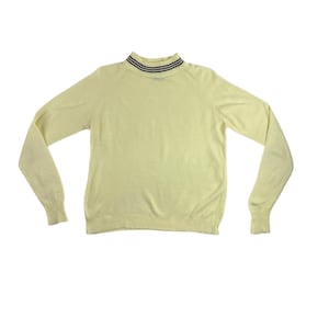 May include: A pale yellow sweater with a mock turtleneck collar. The collar has two navy blue stripes. The long-sleeved sweater is made of a soft knit material and is displayed on a white background.