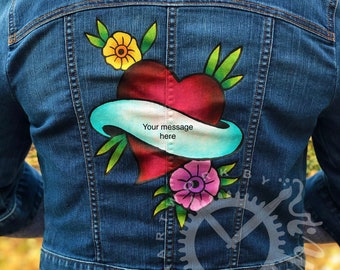 May include: A blue denim jacket with a painted design of a red heart with a blue ribbon and yellow and pink flowers. The ribbon has the text "Your message here" on it.