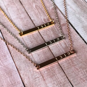 May include: Three gold, silver, and rose gold bar necklaces with the number "1319" engraved on each.