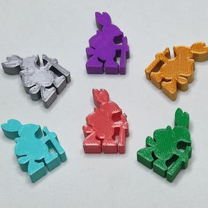 Puede incluir: Seis figuras impresas en 3D de un conejo sosteniendo una espada. Las figuras son de diferentes colores: plateado, morado, naranja, rojo, turquesa y verde.