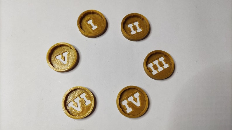 May include: Six gold-colored round tokens with Roman numerals I through VI printed in white.