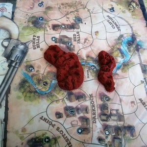 May include: A close-up of a game board with red plastic terrain pieces. The board features the names of locations like "Sunny Hills", "Red Falls", "Dixon Cr", "Darkrock", and "Spike's View".