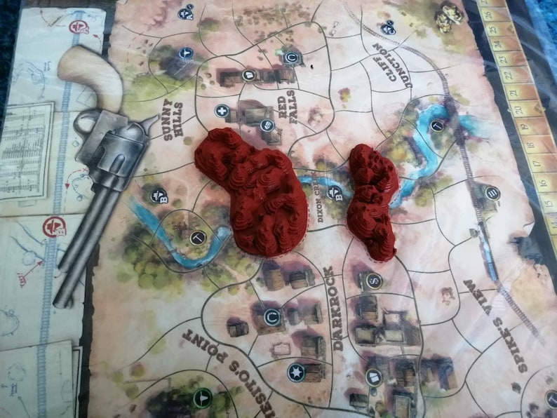 May include: A close-up of a game board with red plastic terrain pieces. The board features the names of locations like "Sunny Hills", "Red Falls", "Dixon Cr", "Darkrock", and "Spike's View".