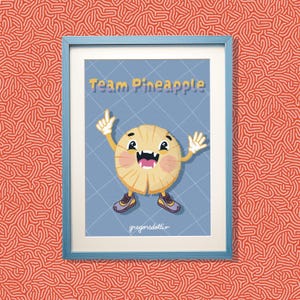 Könnte beinhalten: Ein gerahmter Kunstdruck mit einer Cartoon-Ananasfigur mit breitem Grinsen, die lila-gelbe Turnschuhe trägt, vor einem blauen Hintergrund mit Gittermuster. Der Text Team Pineapple steht oben und gregorsdottir unten auf dem Druck.