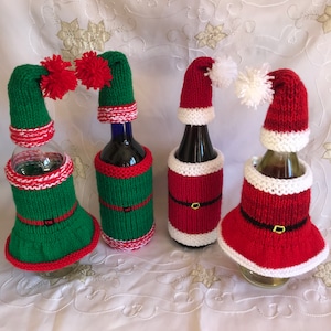 Op de afbeelding: Vier wijnfleshoezen gebreid in kerstthema's. Twee zijn rood-witte kerstmanmutsen, één is een groen-rode elfenmuts en één is een groen-rode elfenlaars.
