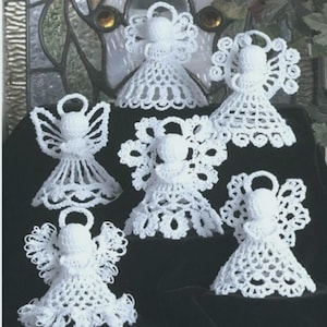 May include: A collection of six white crochet angel ornaments. Each angel features a round head, a halo, and detailed openwork wings and skirts. The angels vary in wing and skirt designs, showcasing a handmade craft aesthetic.