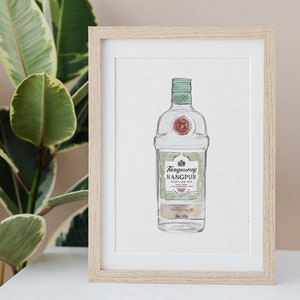 May include: A framed watercolor illustration of a bottle of Tanqueray Rangpur gin. The bottle is green and white with a gold label. The label reads "Tanqueray Rangpur Distilled Gin Made with the Essence of Rangpur Limes."