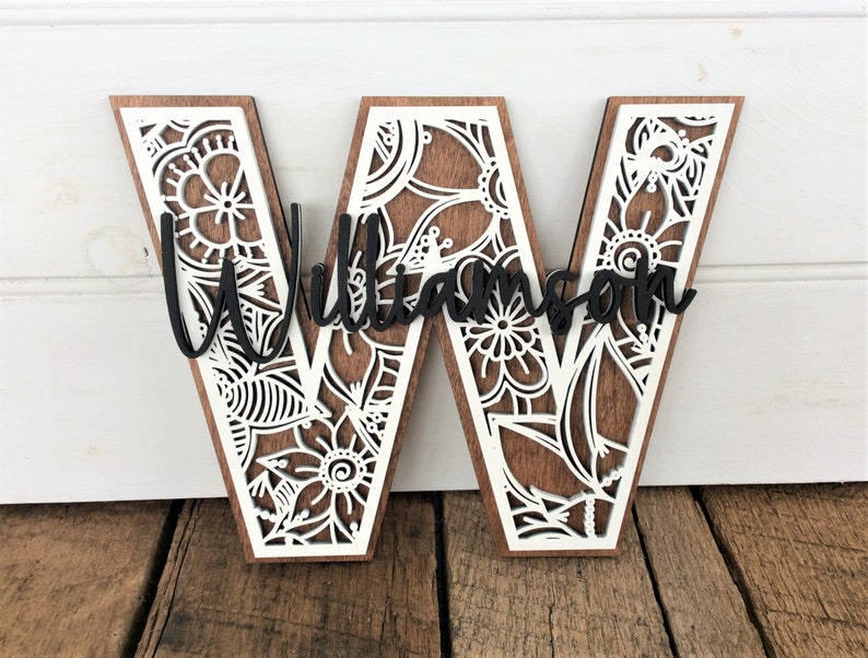 May include: Wooden letter W with a white floral design and the name "Williamson" in black lettering.