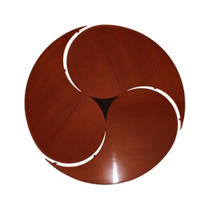 May include: A three-piece wooden table set with a circular design. Each piece is a crescent shape and fits together to form a complete circle. The table is made of a rich, reddish-brown wood.