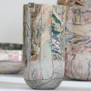 Op de afbeelding: Een set van drie keramische vazen met een marmerpatroon in tinten wit, grijs en bruin. De vazen zijn allemaal in verschillende maten en vormen.