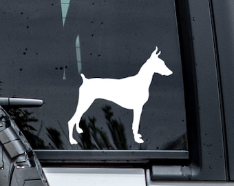 May include: A white silhouette of a Doberman Pinscher dog on a black car window.