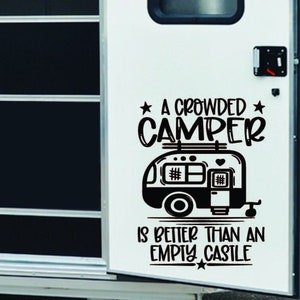 May include: A black and white vinyl decal with the text "A crowded camper is better than an empty castle" and a cartoon image of a camper. The camper has a heart on the side and a roof rack with luggage.