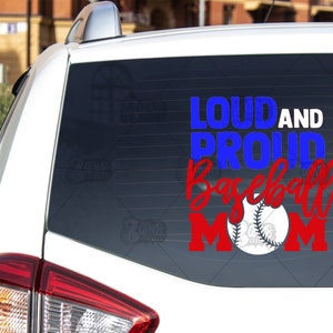 May include: A white car with a blue and red decal on the back window that says "Loud and Proud Baseball Mom" with a baseball graphic. The number 5 is in the bottom right corner of the decal.