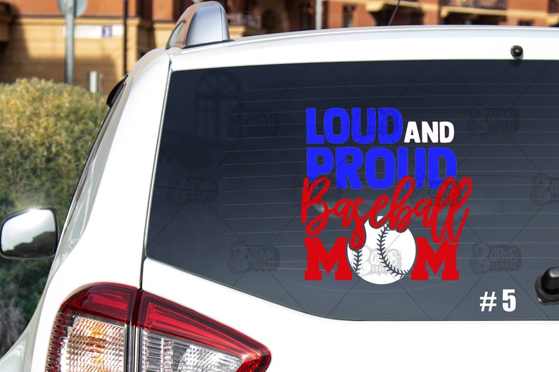 May include: A white car with a blue and red decal on the back window that says "Loud and Proud Baseball Mom" with a baseball graphic. The number 5 is in the bottom right corner of the decal.