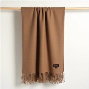 Manta de alpaca bebé color marrón caramelo, ligera y lujosa, para sofá o sillón.