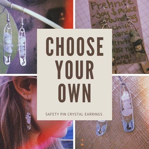May include: A pair of silver safety pin earrings with clear crystals hanging from them. The earrings are displayed on a white background with the text "CHOOSE YOUR OWN SAFETY PIN CRYSTAL EARRINGS".