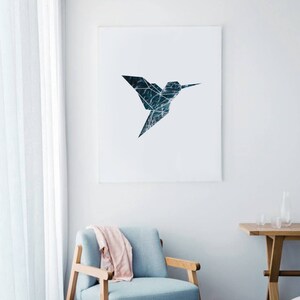 May include: A geometric print of a hummingbird with a blue and green colour scheme. The print is on a white background and is framed in a white frame.