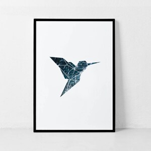 May include: A black framed print of a geometric origami hummingbird with a blue and white water pattern.