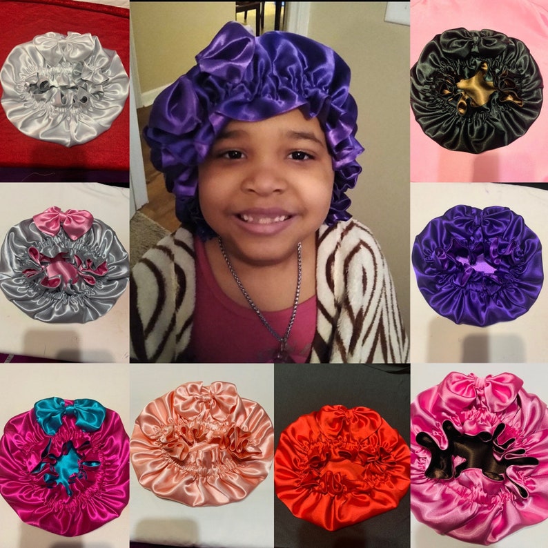 May include: Collection of satin bonnets in various colors, including silver, purple, black, pink, red, and teal. Each bonnet features a gathered design and some are adorned with bows. The bonnets are designed to protect hair.
