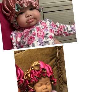 May include: Satin baby bonnet in shades of pink and gold, with a contrasting mint green trim. The bonnet is ruffled and appears to be handmade. The baby is wearing a floral onesie.