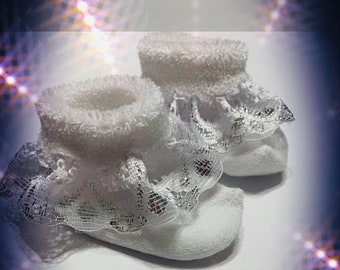 May include: A pair of white baby socks with lace trim. The socks are made of soft, comfortable material and have a delicate, feminine design.