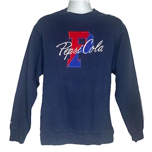 May include: A navy blue sweatshirt with a white "Pepsi Cola" logo and a red and blue "P" embroidered on the front.