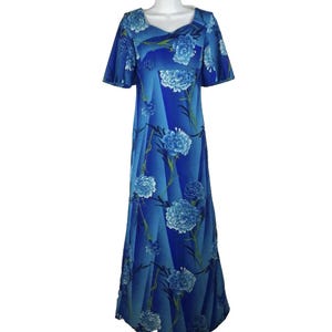 May include: A floor-length dress in shades of blue featuring a repeating floral pattern of light blue carnations with green stems. The garment has short, flared sleeves, a V-neckline, and a straight, flowing silhouette that extends to the floor.