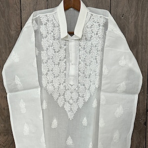 May include: White cotton kurta with intricate white embroidery. The kurta has a collar and a button closure. The embroidery features a floral design.