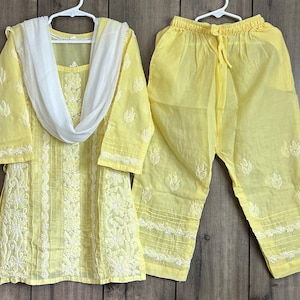 May include: A yellow cotton kurta with white embroidery and a matching pair of pants. The kurta has a white dupatta.