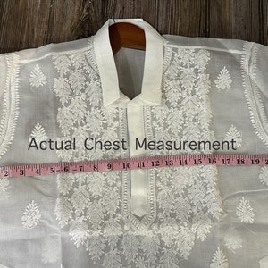 May include: White embroidered shirt with a collar and a tape measure showing a chest measurement of 22 inches.