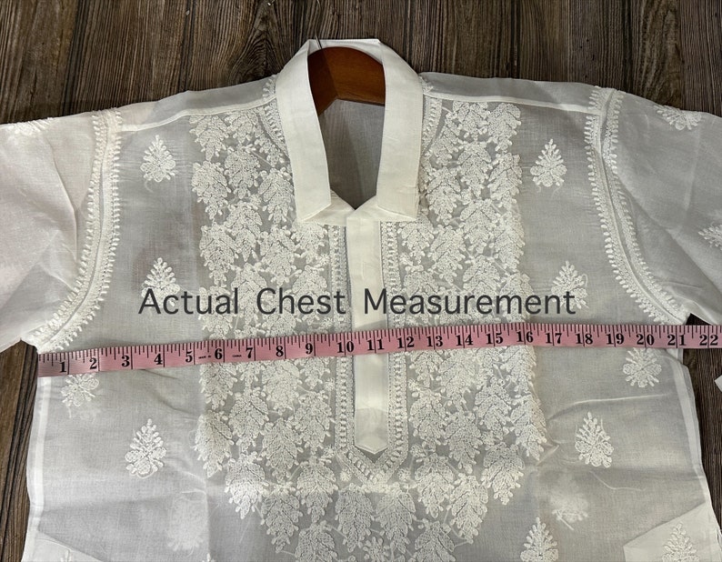 May include: White embroidered shirt with a collar and a tape measure showing a chest measurement of 22 inches.