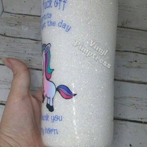 May include: White glitter tumbler with a cartoon unicorn illustration. The tumbler has blue text that reads "fuck off", "tits", "get the day", "thank you", and "my horn".