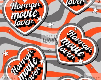 May include: A repeating pattern of orange hearts with white outlines on a gray and orange striped background. The hearts have the text "Horror movie lover" in white with a black outline. There are white stars scattered throughout the pattern.