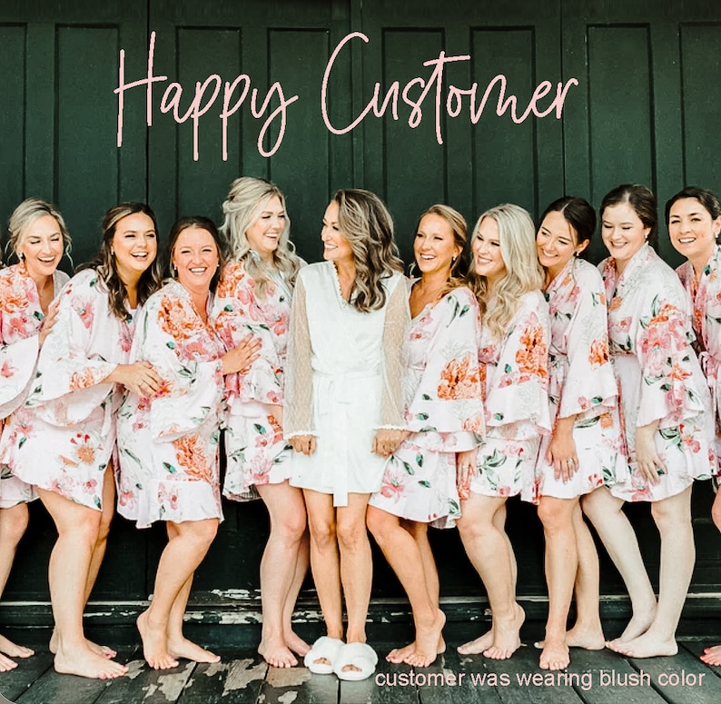 Puede incluir: Un grupo de mujeres vistiendo batas de estampado floral rosa con ribetes blancos. La mujer del centro lleva una bata blanca con ribetes de encaje. El texto "Happy Customer" est&aacute; escrito en rosa sobre las mujeres.