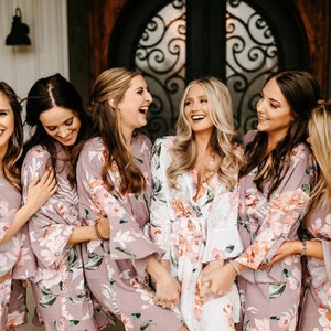 Puede incluir: Un grupo de mujeres con batas de estampado floral en tonos rosa y blanco. Sonr&iacute;en y r&iacute;en juntas, creando un ambiente divertido y festivo.