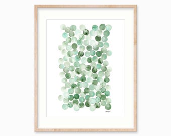 May include: A framed wall art print featuring a vertical arrangement of numerous watercolor circles in varying shades of green, ranging from pale mint to deep forest tones, set against a white background within a light-colored wooden frame.