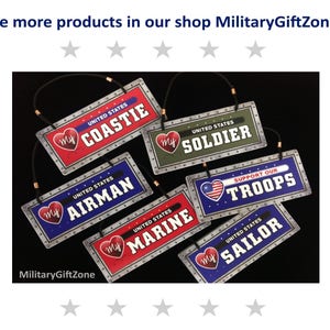 May include: Six metal signs with a heart and the words "My" and a branch of the United States military printed on them. The signs are red, blue, green, and silver with a black background. The signs say "My Coastle", "My Soldier", "My Airman", "My Marine", "Support Our Troops", and "My Sailor".