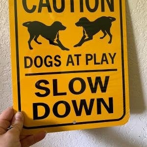 Precaución: perros jugando. Reduzca la velocidad. Lindo letrero de aluminio para jardín