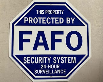 May include: White and blue octagonal security sign with the text "THIS PROPERTY PROTECTED BY FAFO SECURITY SYSTEM 24-HOUR SURVEILLANCE". The sign has two small holes at the top for mounting.