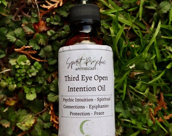 Puede incluir: Una botella de vidrio marrón con un gotero negro y una etiqueta blanca. La etiqueta dice "Spirit Psychic - Apothecary - Third Eye Open Intention Oil - Psychic Intuition - Spiritual Connections - Epiphanies - Protection - Peace - WWW.SPIRITPSYCHIC.ORG - 2 oz."