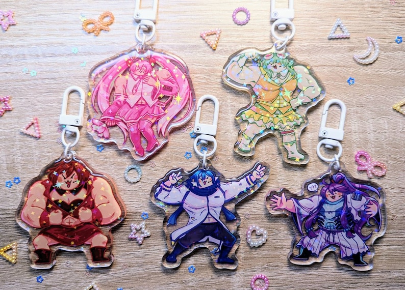 Puede incluir: Cinco llaveros de personajes de anime coloridos con detalles de purpurina. Cada llavero presenta un personaje diferente con una pose y una expresi&oacute;n &uacute;nicas. Los llaveros est&aacute;n hechos de acr&iacute;lico transparente y tienen un cierre de metal plateado.