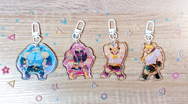 Puede incluir: Cuatro llaveros de personajes de anime coloridos con detalles de purpurina. Cada llavero presenta un personaje diferente con una pose y una expresi&oacute;n &uacute;nicas. Los llaveros est&aacute;n unidos a anillos met&aacute;licos plateados.