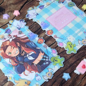 May include: Two Final Fantasy themed acrylic charms with a light blue and white checkered pattern. One charm features a smiling anime character, the other has the text "Welcome to Final Fantasy". The charms are decorated with various character illustrations.