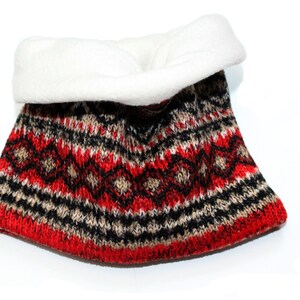 Könnte beinhalten: Roter, schwarzer und beiger gestrickter Halsschmeichler mit weißem Fleecefutter.