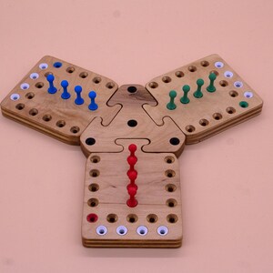 May include: A wooden triangular game board with three sections. Each section has a grid of holes with pegs in them. The pegs are blue, green, and red.